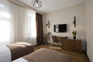 a hotel room with a bed and a desk and a tv at Snog Rooms & Suites in Istanbul