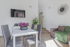 Una sala de estar con una mesa y sillas y un sofá. en Maggie House, en Piacenza