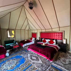 a bedroom with two beds in a tent at Authentic Luxury Camp in Merzouga