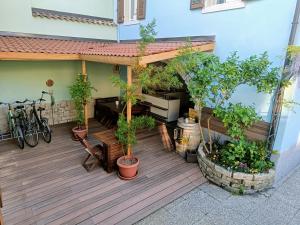 a deck with plants and a bench and a bike at Il Bosco apartment in Arco