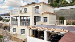 una casa con un coche aparcado delante de ella en 4 bedrooms villa with sea view private pool and furnished terrace at Callosa de Ensarria 9 km away from the beach, en Callosa de Ensarriá