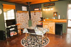 sala de estar con mesa y cocina en Hyde Hollow Cabin, en Eureka Springs