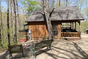 una cabaña de madera con un banco delante en Hyde Hollow Cabin, en Eureka Springs
