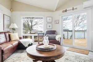 a living room with a couch and a table at Private waterfront cottage - hot tub & kayaks in Kingston