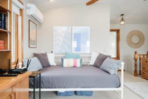 a bed in a room with a desk and a window at Private waterfront cottage - hot tub & kayaks in Kingston