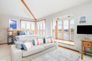 a living room with a couch and a tv at Private waterfront cottage - hot tub & kayaks in Kingston