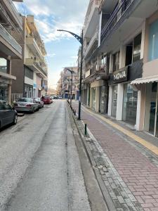 an empty street in a city with cars parked at PARASIOU STUDIOS 102 διαμερίσματα στο κέντρο της πόλης in Komotini