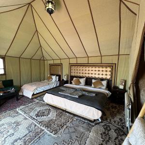 a bedroom with two beds in a tent at Authentic Luxury Camp in Merzouga