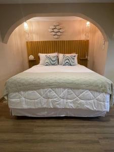 a bedroom with a large white bed with two pillows at Cinque Terre Pousada & Bistrô in Rio de Janeiro