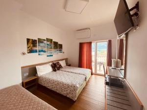 ein Hotelzimmer mit 2 Betten und einem Balkon in der Unterkunft Hotel Garni Montaldi in Locarno