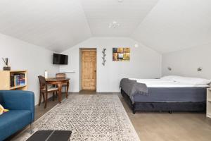 una camera con letto, tavolo e divano di Rauðafell ChickenCoop a Skogar