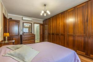 a bedroom with wooden cabinets and a large bed at 3BR Mediterranean Oasis Retreat in San Giljan, Malta in St. Julianʼs