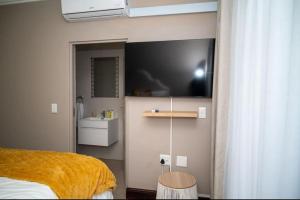 a bedroom with a bed and a tv on the wall at 203 Marina Bay Luxury Apartments Suite, Umhlanga in Durban +16 photos