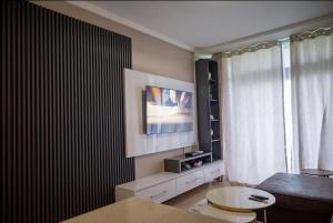 a living room with a tv on the wall and a table at 203 Marina Bay Luxury Apartments Suite, Umhlanga in Durban