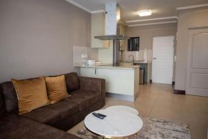 a living room with a couch and a table and a kitchen at 203 Marina Bay Luxury Apartments Suite, Umhlanga in Durban