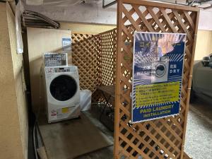 a washing machine and a sign in a room at ホテルアイエス in Yokohama