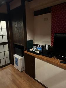 a hotel room with a desk with a television and a counter at ホテルアイエス in Yokohama