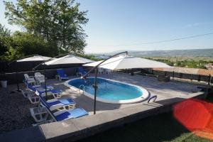 una piscina con sombrillas y tumbonas en Villa Apa, en Runović