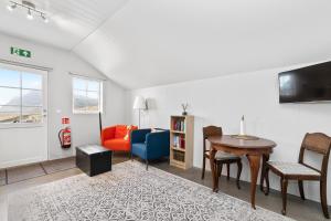 a living room with a table and a couch at Rauðafell ChickenCoop in Skogar