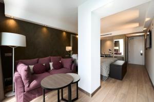 a living room with a purple couch and a table at Catalonia Square 4* Sup in Barcelona