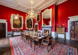 una sala da pranzo con un lungo tavolo e un camino di Wolterton Hall a Itteringham