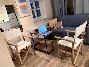 een woonkamer met een bank en een laptop op een tafel bij Orpheus Guesthouse in Athene +16 foto's