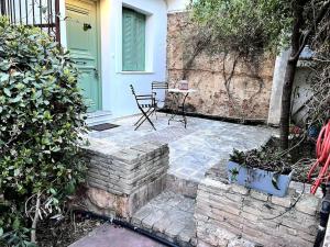 een patio met een tafel en een stoel voor een deur bij Orpheus Guesthouse in Athene