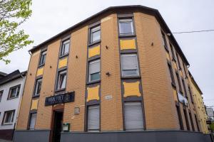 a brown brick building with yellow paint on it at Honeybee Properties Winningen in Winningen