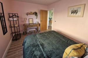 1 dormitorio con cama y escritorio. en Gleann Ciuin, en Ballymartin