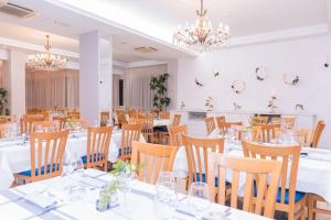 una sala da pranzo con tavoli, sedie e lampadari a braccio di Hotel Elios a Bellaria-Igea Marina