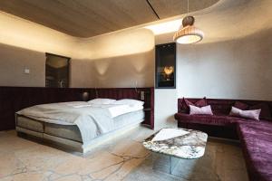 1 dormitorio con 1 cama grande y 1 sofá en Wachtler Dolomite Apartments, en San Candido
