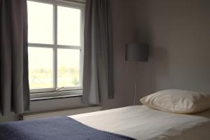 una camera da letto con un letto e una finestra di Guesthouse Oeyenbos a Knegsel