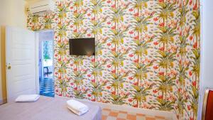a bedroom with a wall with a wallpaper with a tv on it at Sibylla in Rome in Rome
