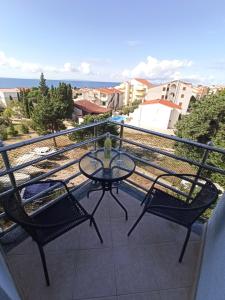 a glass table and two chairs on a balcony at Apartment SKY in Novalja
