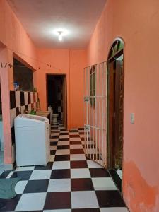 um quarto com uma parede laranja e um piso xadrez em Casa Itaúnas em Itaúnas
