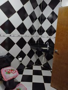 uma casa de banho com piso em xadrez preto e branco em Casa Itaúnas em Itaúnas