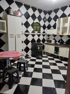 uma cozinha com piso em xadrez preto e branco em Casa Itaúnas em Itaúnas