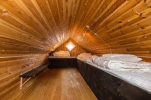 um amplo quarto de madeira com 2 camas num chalé de madeira em Skipperhuset em Sørvær