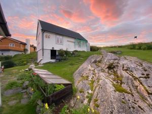 um edifício com um banco em frente a um campo em Skipperhuset em Sørvær