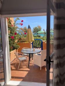 eine Terrasse mit einem Tisch, einem Stuhl und einem Sonnenschirm in der Unterkunft Estudio Naturista vista al mar in Vera