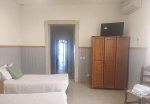 a bedroom with a bed and a dresser with a television at Hotel Bela Vista in Olhão