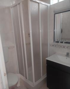 een badkamer met een douche, een toilet en een wastafel bij Hotel Bela Vista in Olhão
