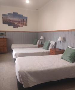 een hotelkamer met 2 bedden en groene kussens bij Hotel Bela Vista in Olhão