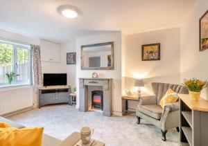 a living room with a couch and a fireplace at Craig Cottage in Aylsham