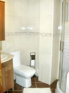 a white bathroom with a toilet and a sink at 3 bedrooms villa with private pool furnished garden and wifi at Segoes 