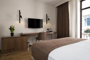 a bedroom with a bed and a desk and a television at Snog Rooms & Suites in Istanbul