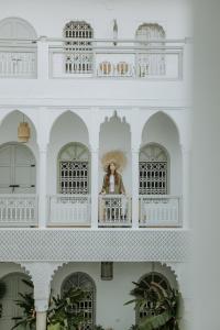 a woman standing on a balcony of a white building at Riad Oriental Glory & Spa in Marrakesh