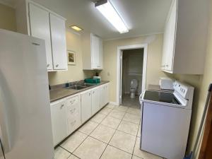 a kitchen with white cabinets and a sink and a toilet at Boulders Resort in Lake George