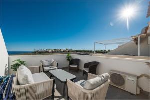 einen Balkon mit Stühlen und einem Tisch sowie Strandblick in der Unterkunft Stunning Duplex with Sea Views in Gran Alacant