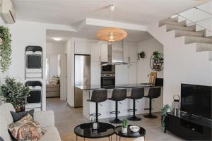 uma sala de estar com uma cozinha e uma sala de estar com um bar em Stunning Duplex with Sea Views em Gran Alacant